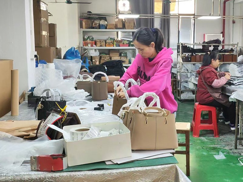 Workers sewing canvas and fabric bags on a production line using industrial machines in a professional manufacturing workshop.