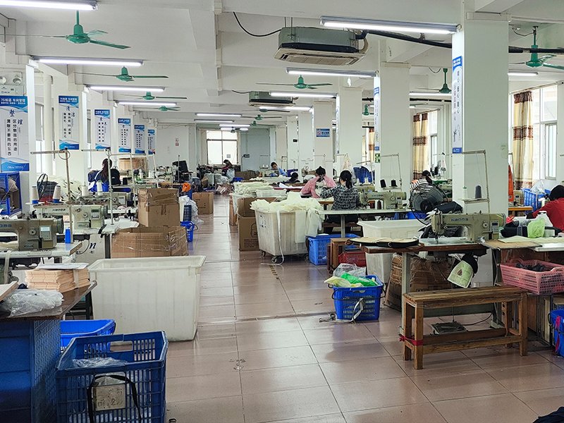 Bag production line with workers sewing canvas bags in factory